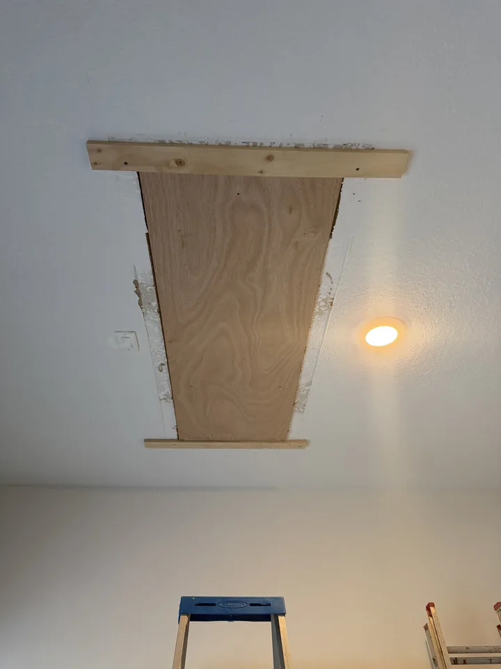 The SilverLeaf attic opening boarded with a plywood panel and timber batten during the install