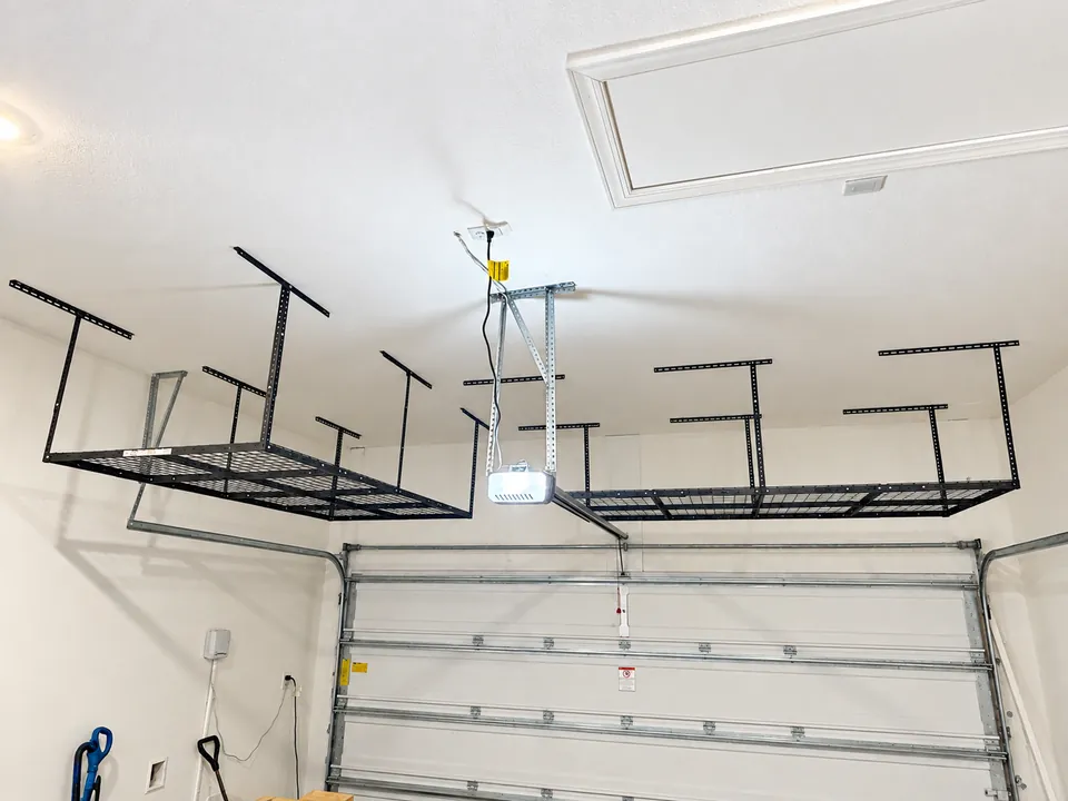 Two black overhead storage racks installed either side of the opener on the same SilverLeaf garage ceiling