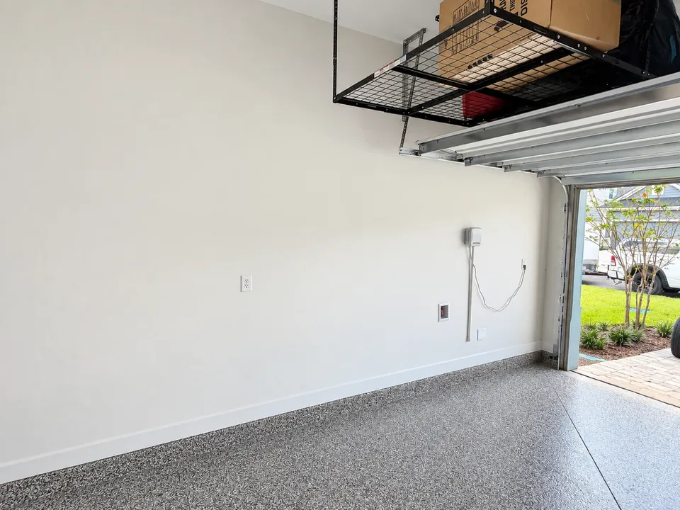 Blank SilverLeaf garage wall before the tool rails went up, with an overhead rack already installed above