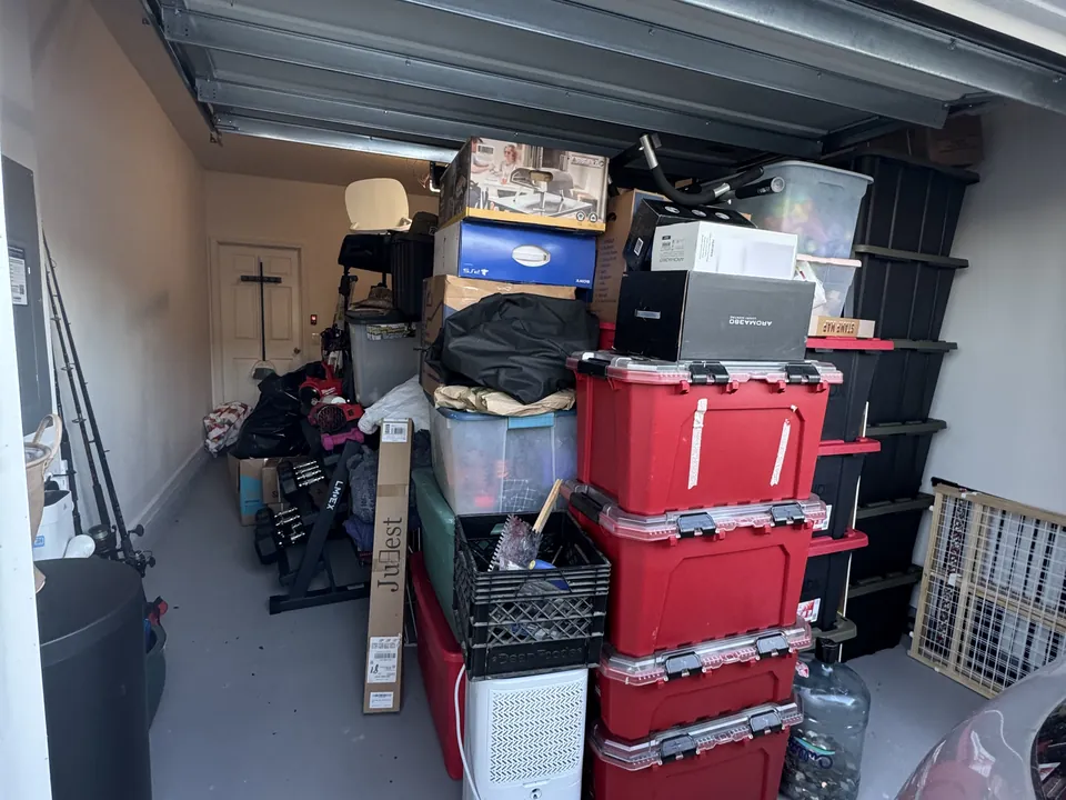 SilverLeaf garage floor before organization, covered with suitcases, coolers, crates and boxes