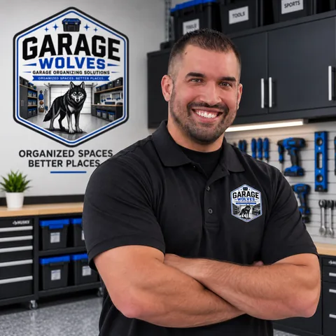 Shaunn of Garage Wolves, arms crossed in a Garage Wolves polo, in an organized garage